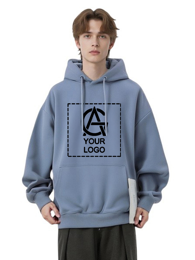 A young person wears a loose-fitting, light blue 310GSM Unisex Pullover Hoodie with a front pocket. The chest features a placeholder box displaying “YOUR LOGO” and a stylized “A” inside the box.