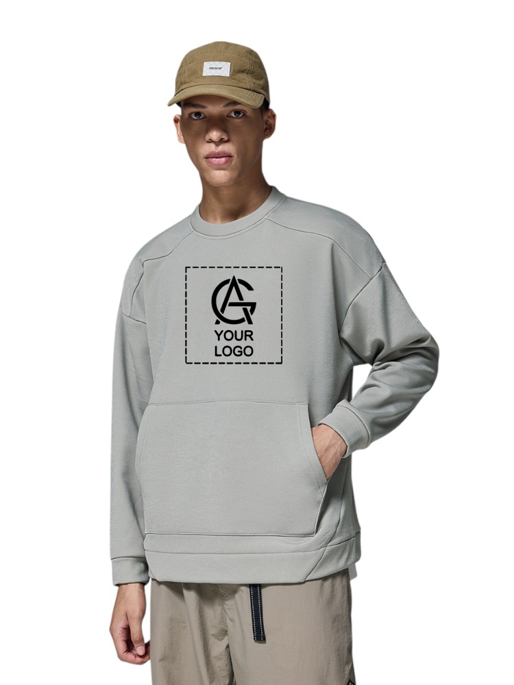 A person wearing a light gray sweatshirt with a customizable "Your Logo" graphic on the chest and a beige cap, standing with one hand in the sweatshirt pocket against a plain white background.