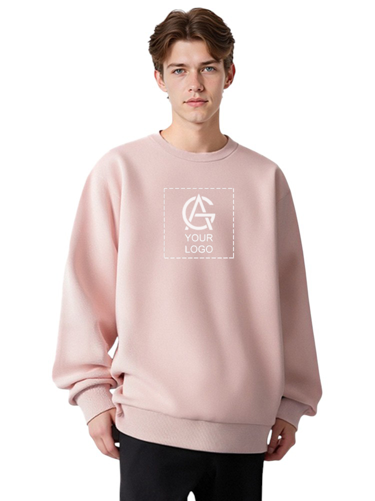 Young man with light brown hair wearing a loose, light pink sweatshirt with a customizable "Your Logo" design on the front, standing against a plain white background.
