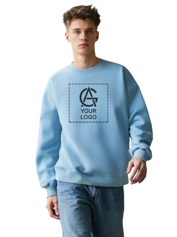 A young person wearing a light blue sweatshirt with a placeholder square and the text "YOUR LOGO" printed on the front, paired with blue jeans, standing against a plain white background.