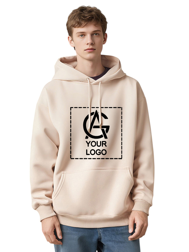 A young man wearing a light beige hoodie with a front pocket. The hoodie has a large, square graphic on the chest featuring a placeholder logo and the words "YOUR LOGO" inside a dashed outline.