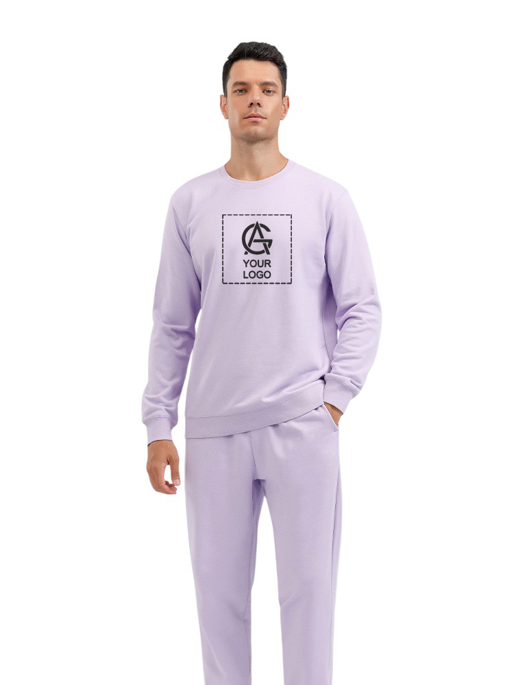 A man wearing a light purple sweatshirt and matching pants stands with one hand in his pocket. The sweatshirt features a placeholder logo and the text "YOUR LOGO" on the chest. He is facing forward against a white background.