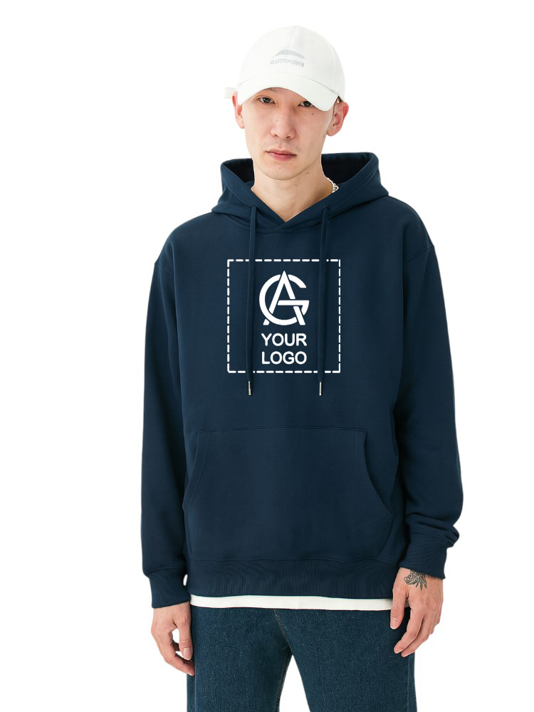 A person wearing a white cap, navy blue hoodie with a graphic and the words “YOUR LOGO” on the front, and blue jeans stands facing forward against a plain white background.