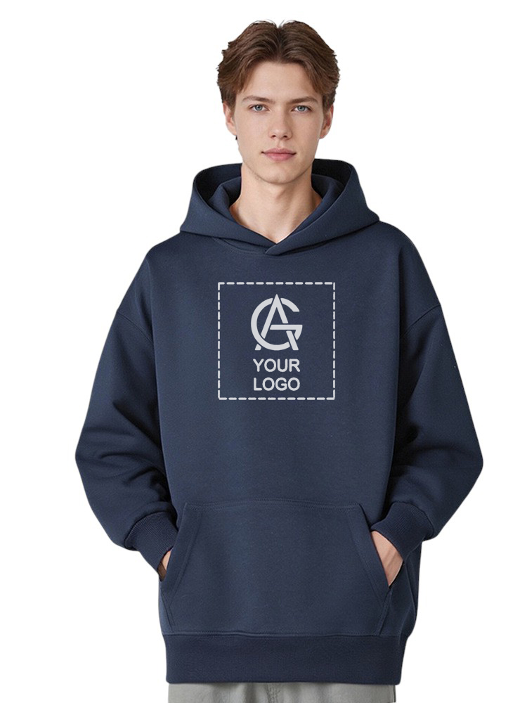 A young man wearing a navy blue hoodie with hands in pockets. The hoodie features a square outline and the text "YOUR LOGO" in the center, with a placeholder graphic above the text.