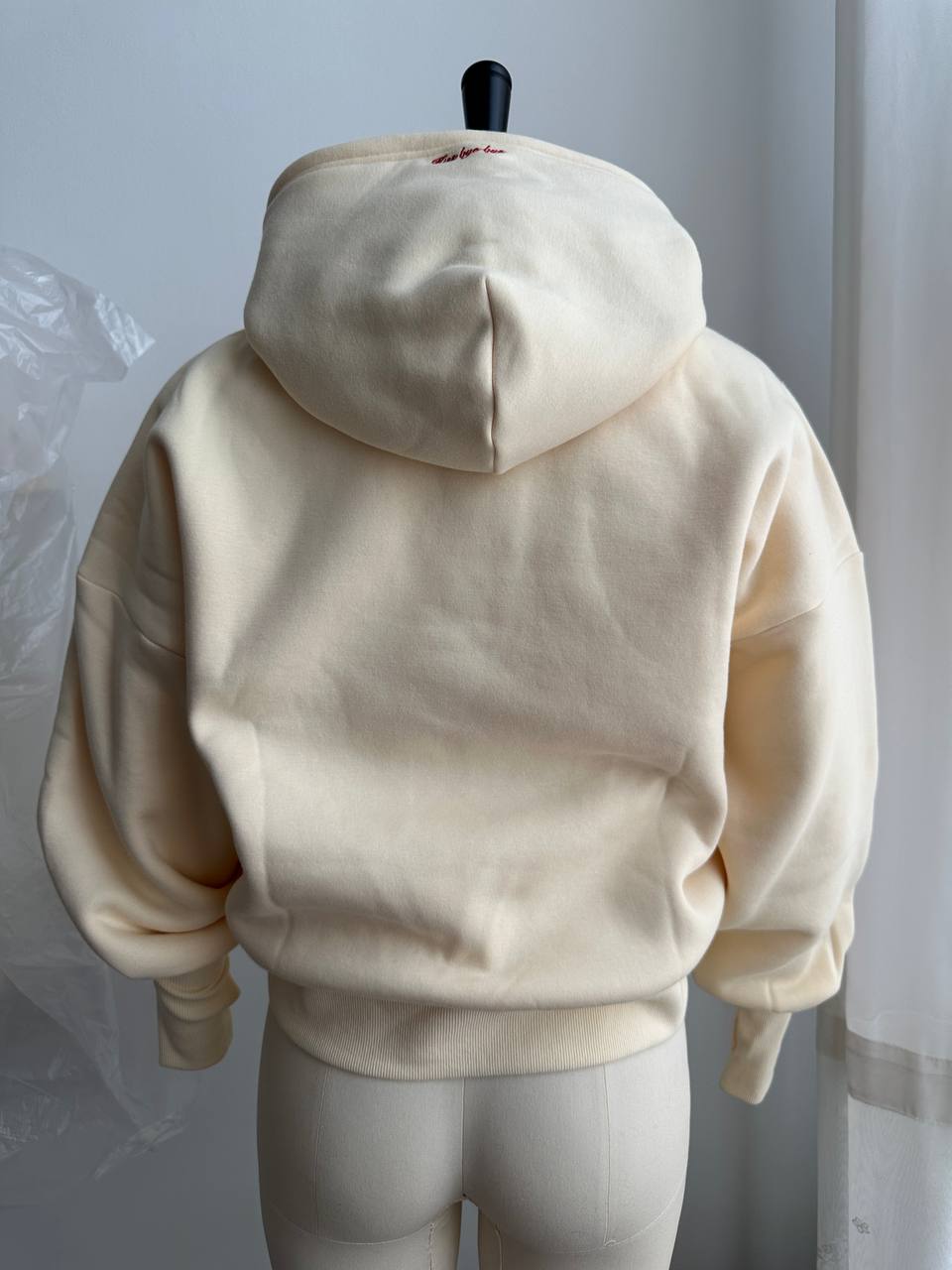 Back view of the finished cream hoodie showing the structured hood