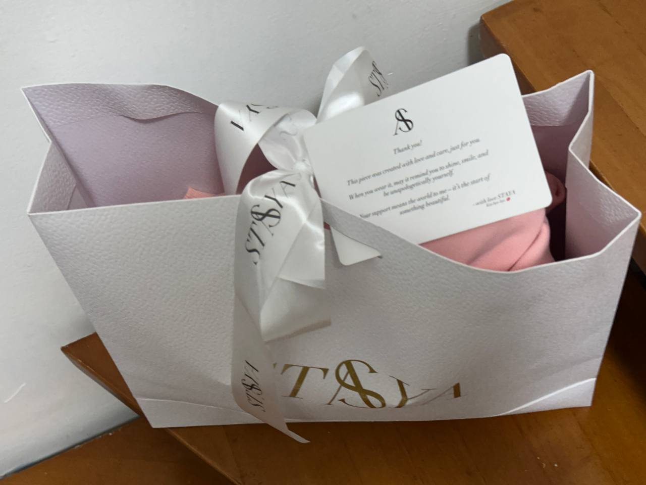 Pink custom hoodie packed with branded ribbon and customer card
