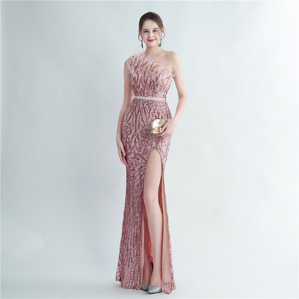 Model wearing a blush pink sequin evening gown with feather trim