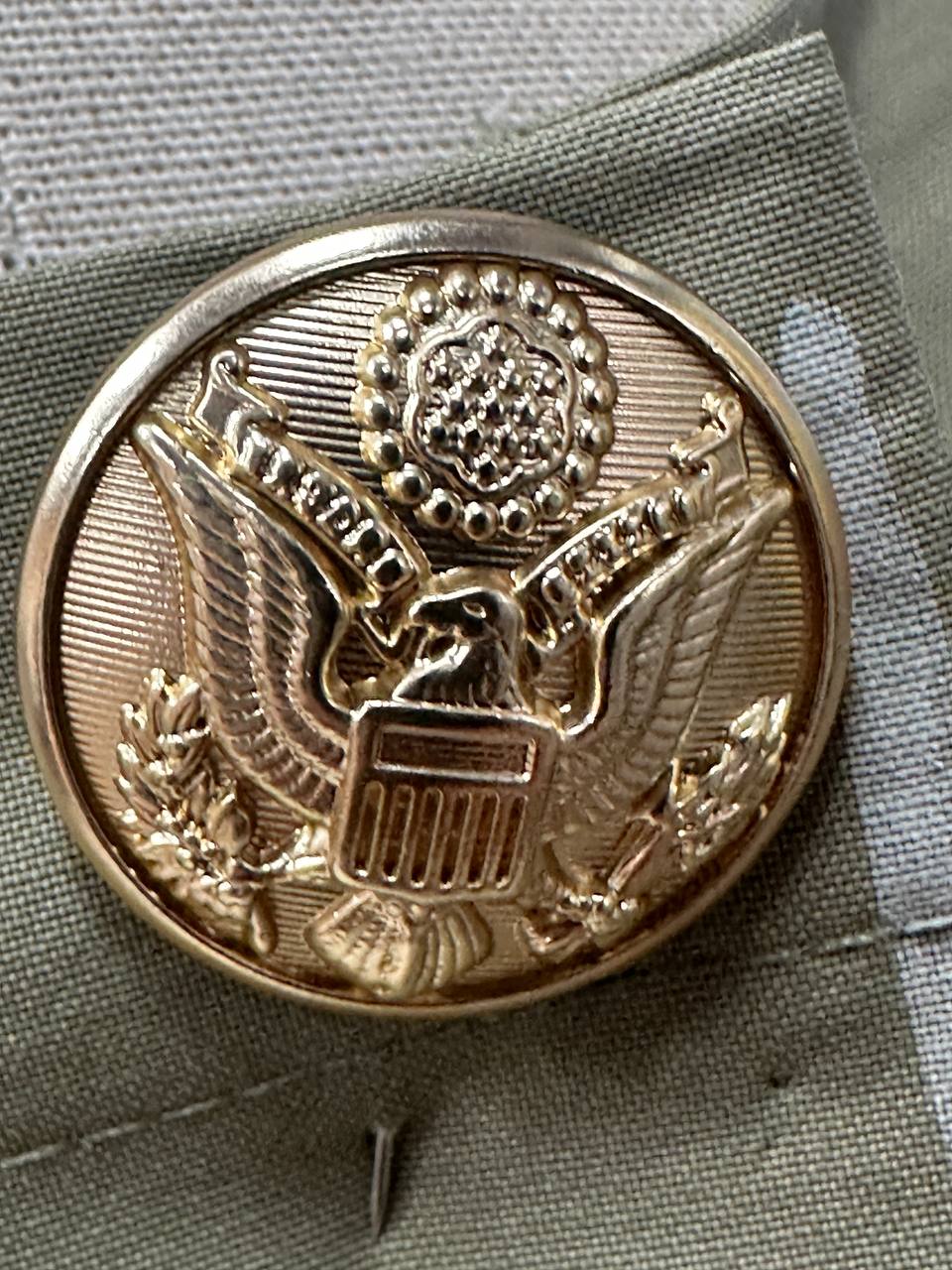 Close-up of custom gold eagle button developed for restaurant staff uniforms