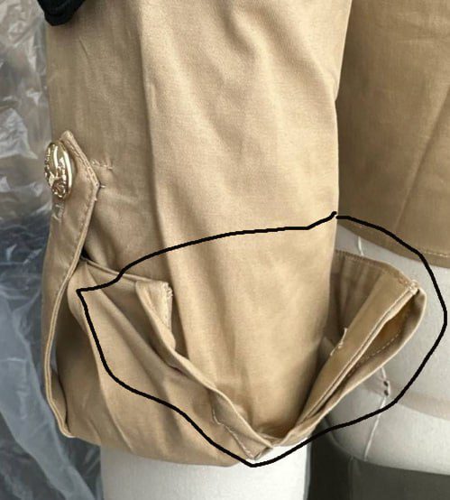 Close-up of roll-tab sleeve detail with custom eagle button on restaurant uniform shirt
