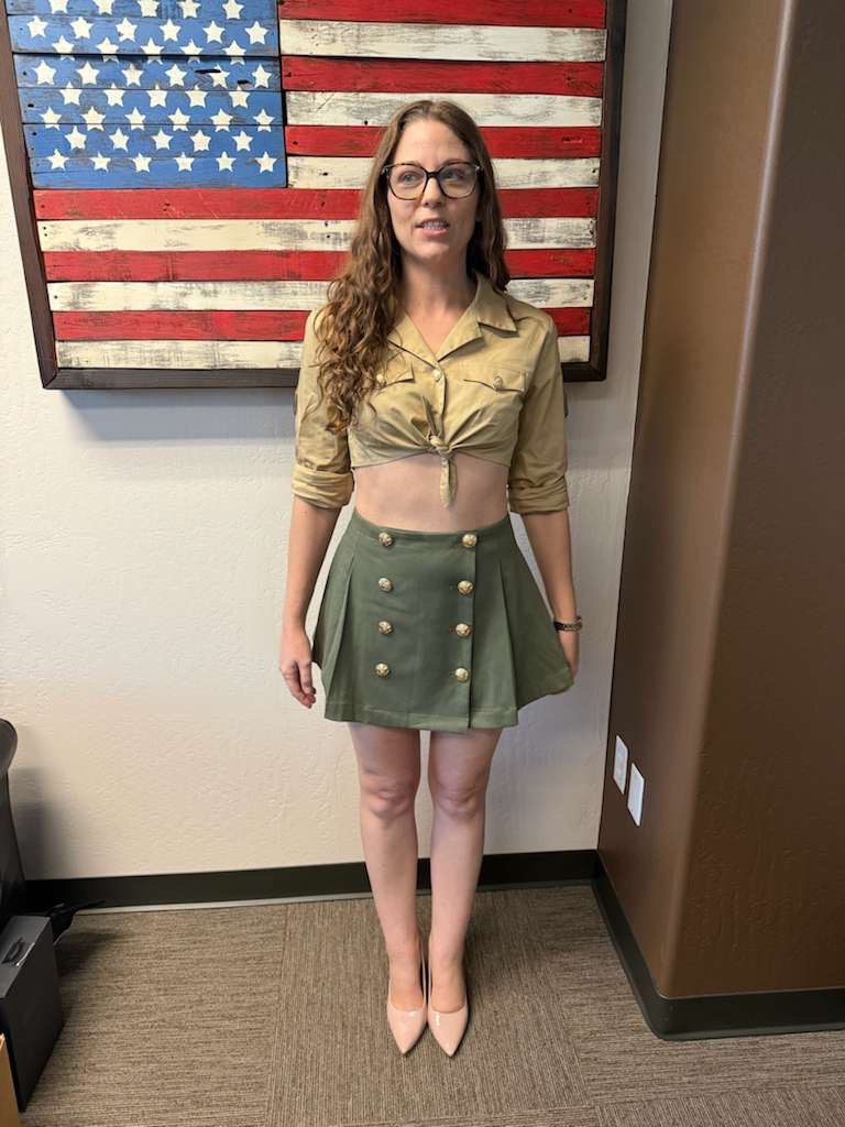 Front view of women’s custom restaurant uniform with tie-front crop top and buttoned pleated skirt