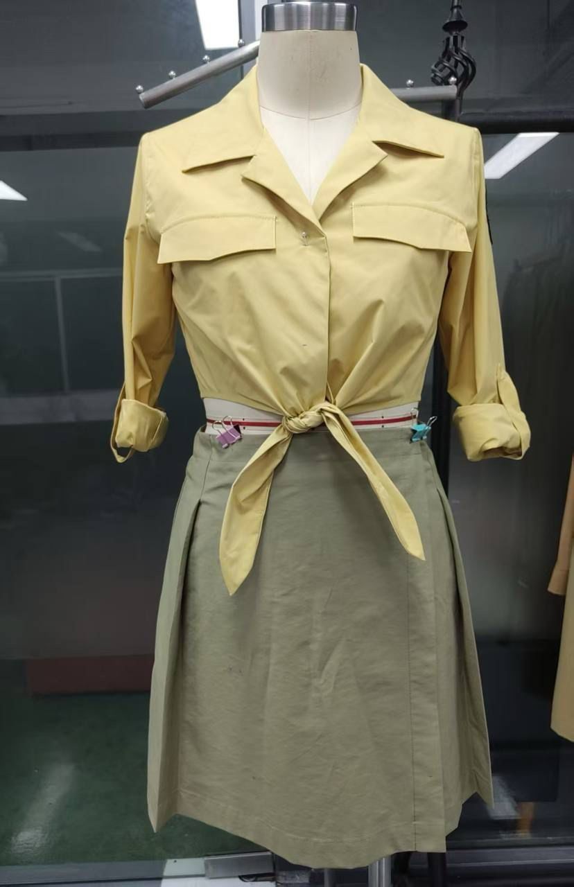 Women’s custom restaurant uniform sample with tie-front shirt and pleated skirt during fit development