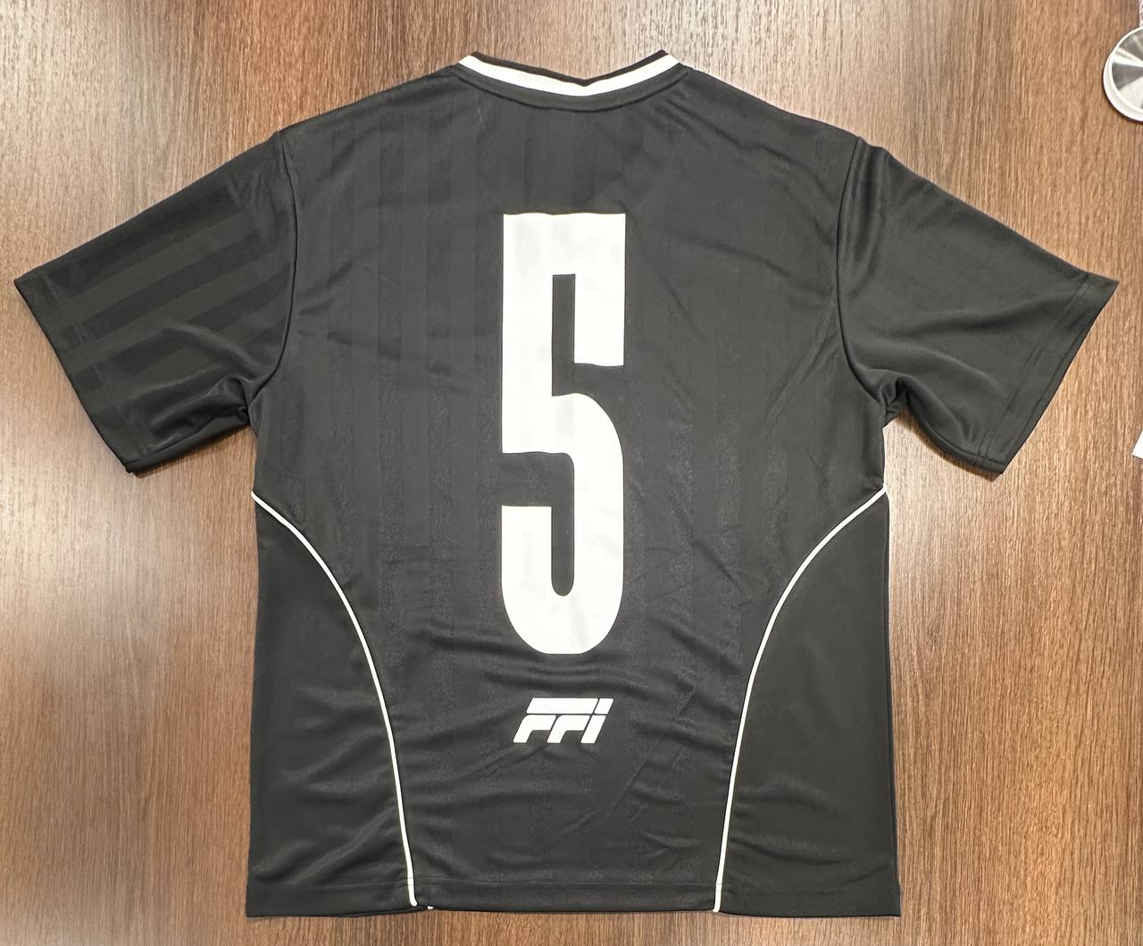 Back view of custom black jersey with number 5 and printed logo