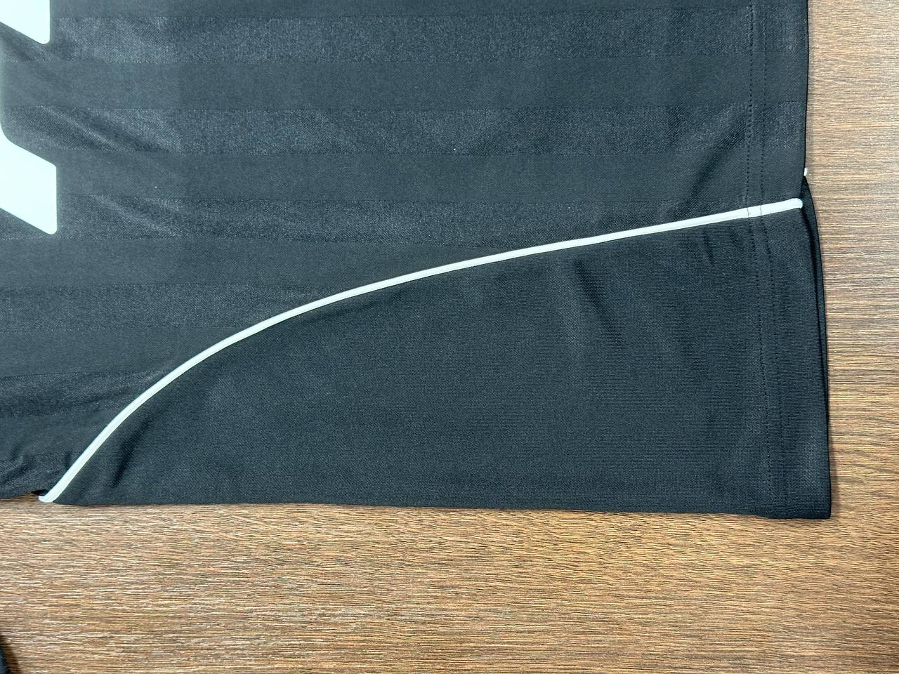 Close-up of contrast piping detail on a black custom jersey