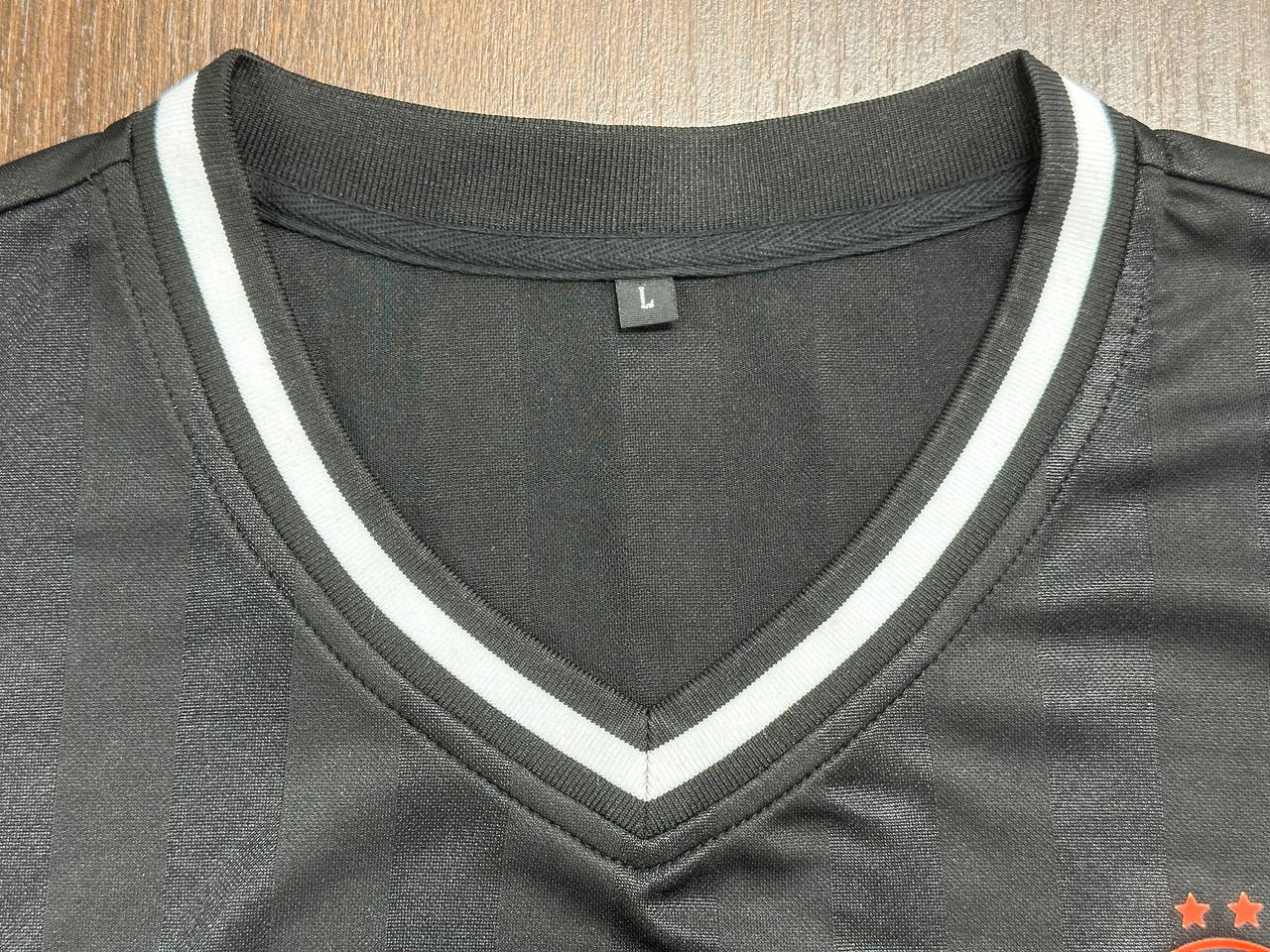 Close-up of striped V-neck collar and size label on custom jersey