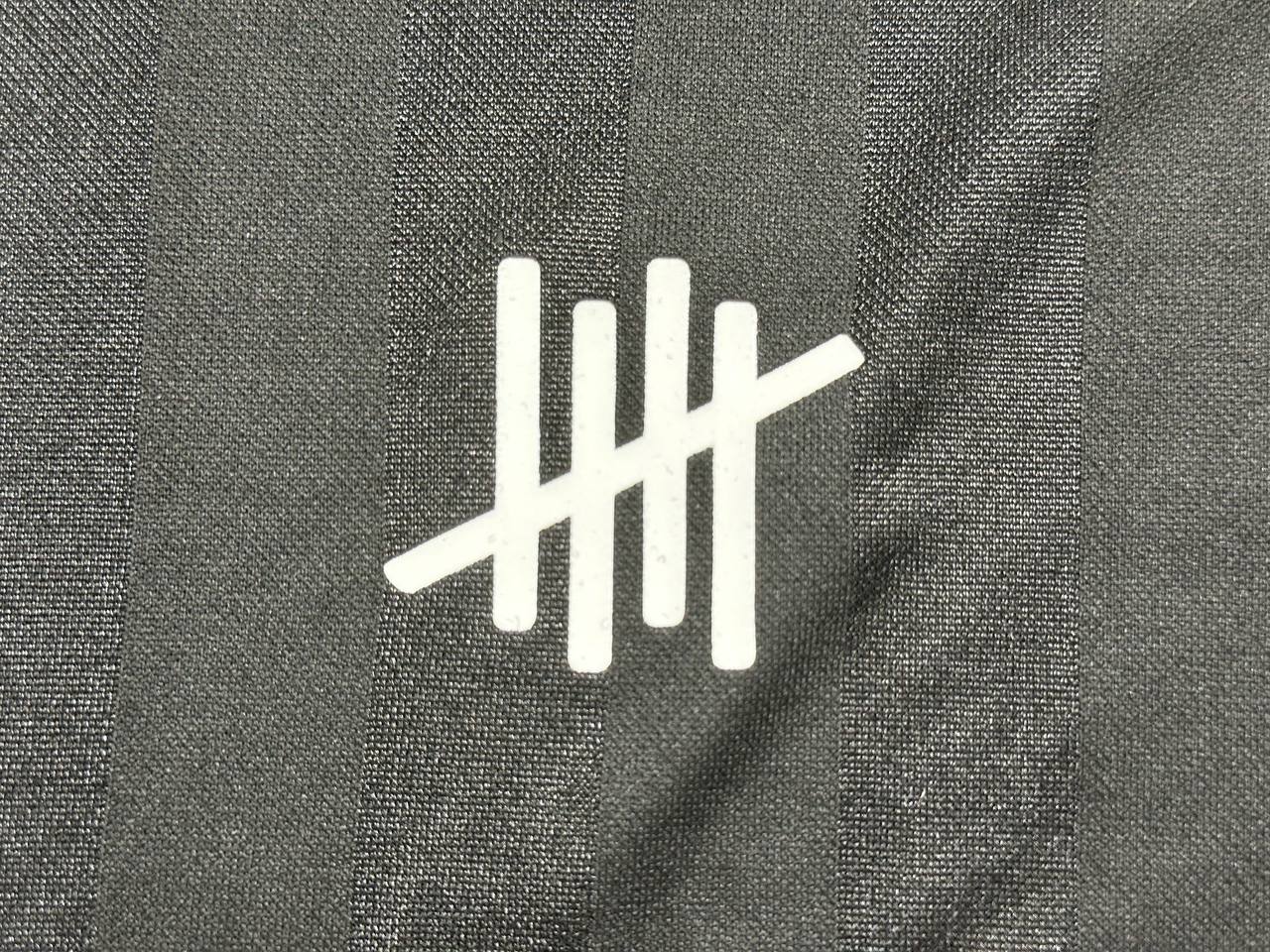 White printed logo detail on black custom jersey